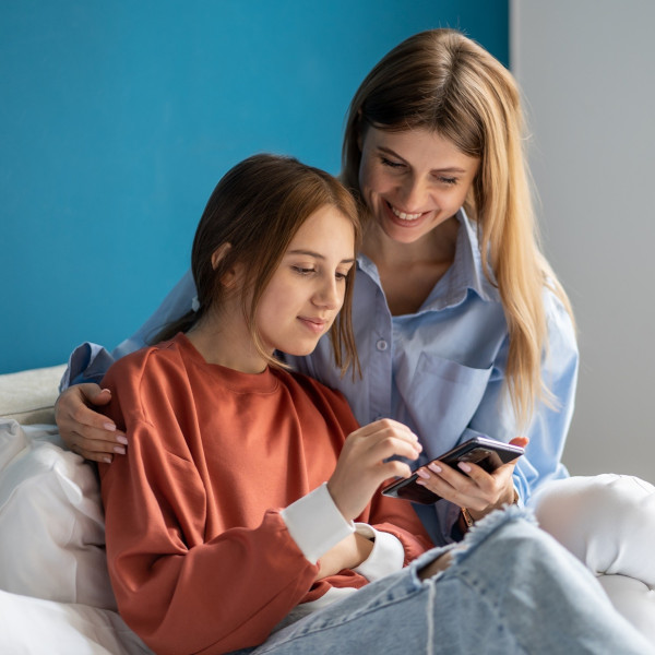 mom and daughter using smartphone